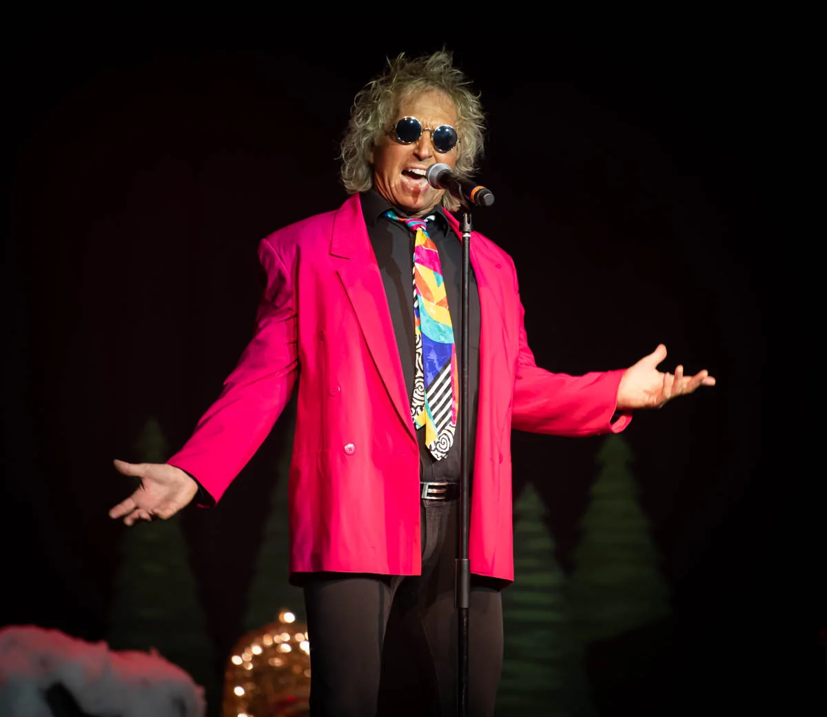 Alby Good singing in a pink jacket