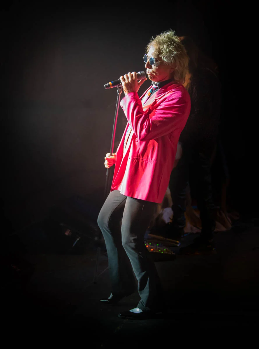 Alby Good performing into a hand-held microphone